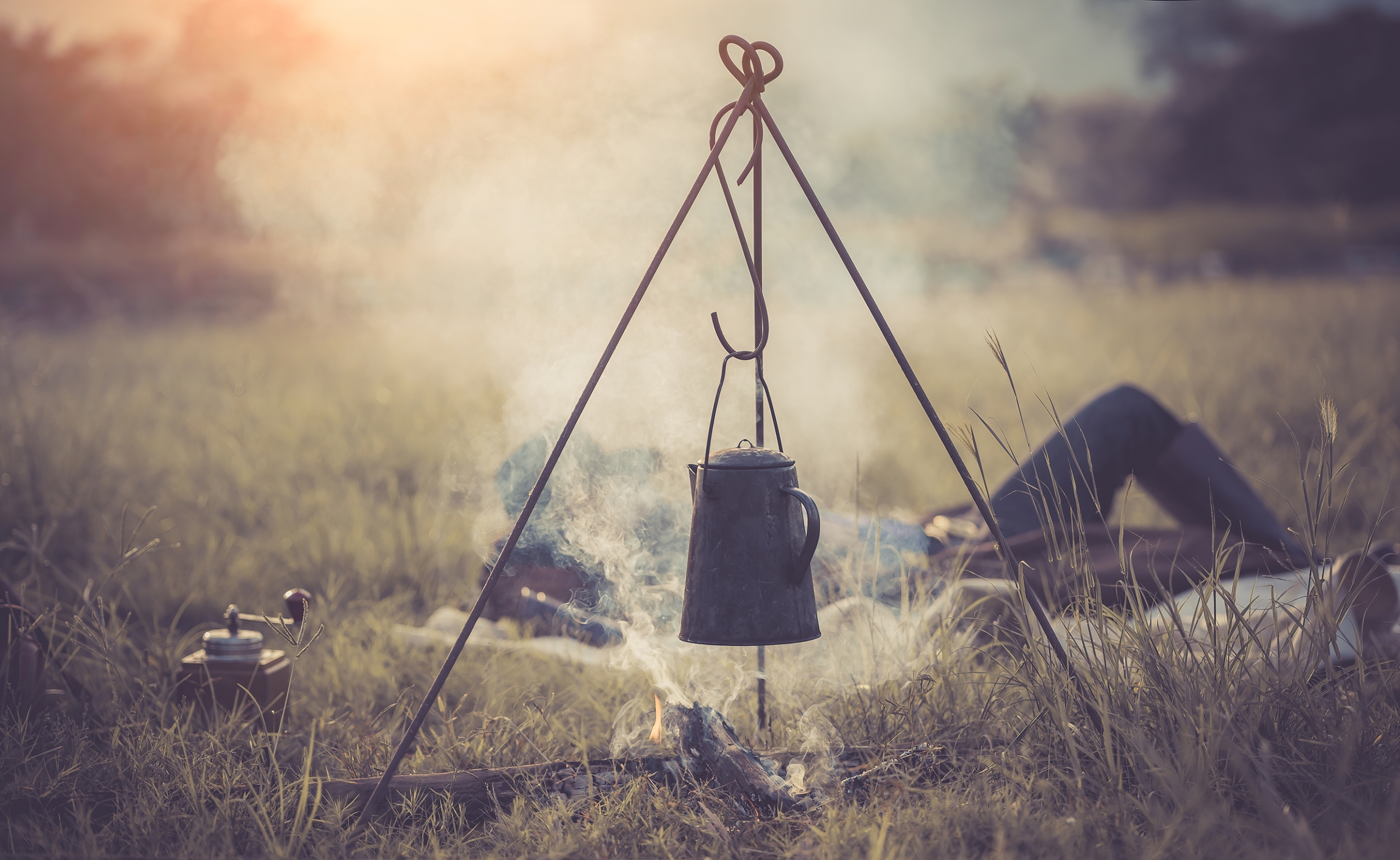 Cowboy outdoor camping with kettle over fire